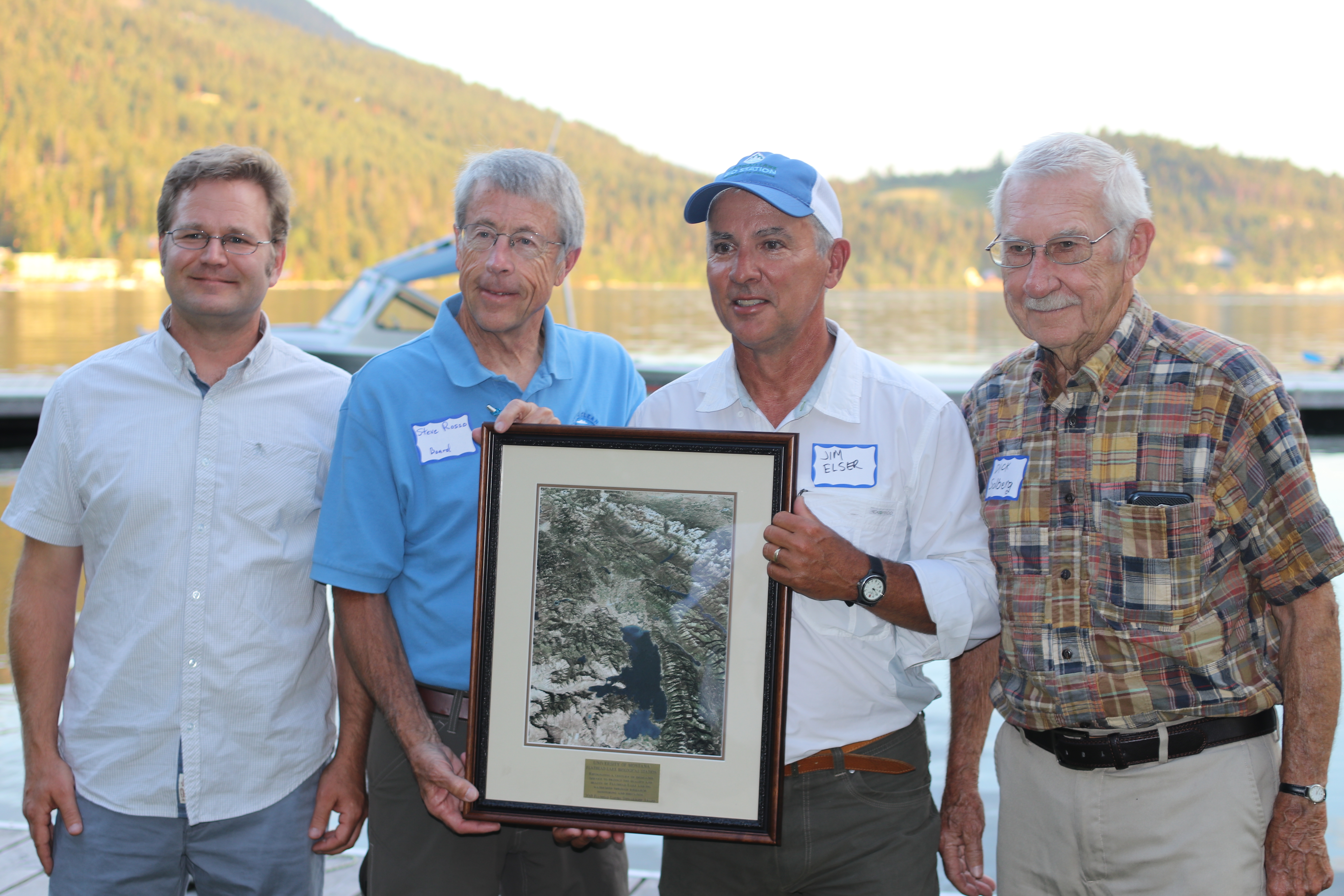 Flathead Lakers president Steve Rosso presents the 2018 Flathead Lakers Stewardship award to FLBS Assistant Director Tom Bansak, FLBS Director Jim Elser, and former FLBS Director Dick Solberg