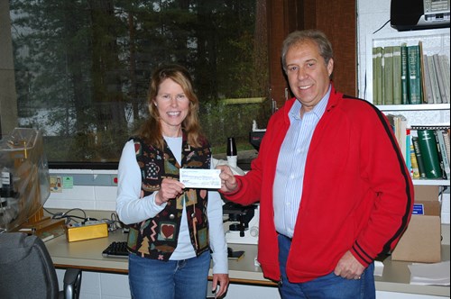 Bruce Young handing a check to Bonnie Ellis (retired FLBS researcher).