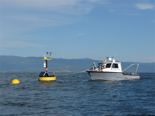 Researchers aboard the Jessie B hold the new Flathead Lake midlake VOEIS buoy in place during anchor deployment
