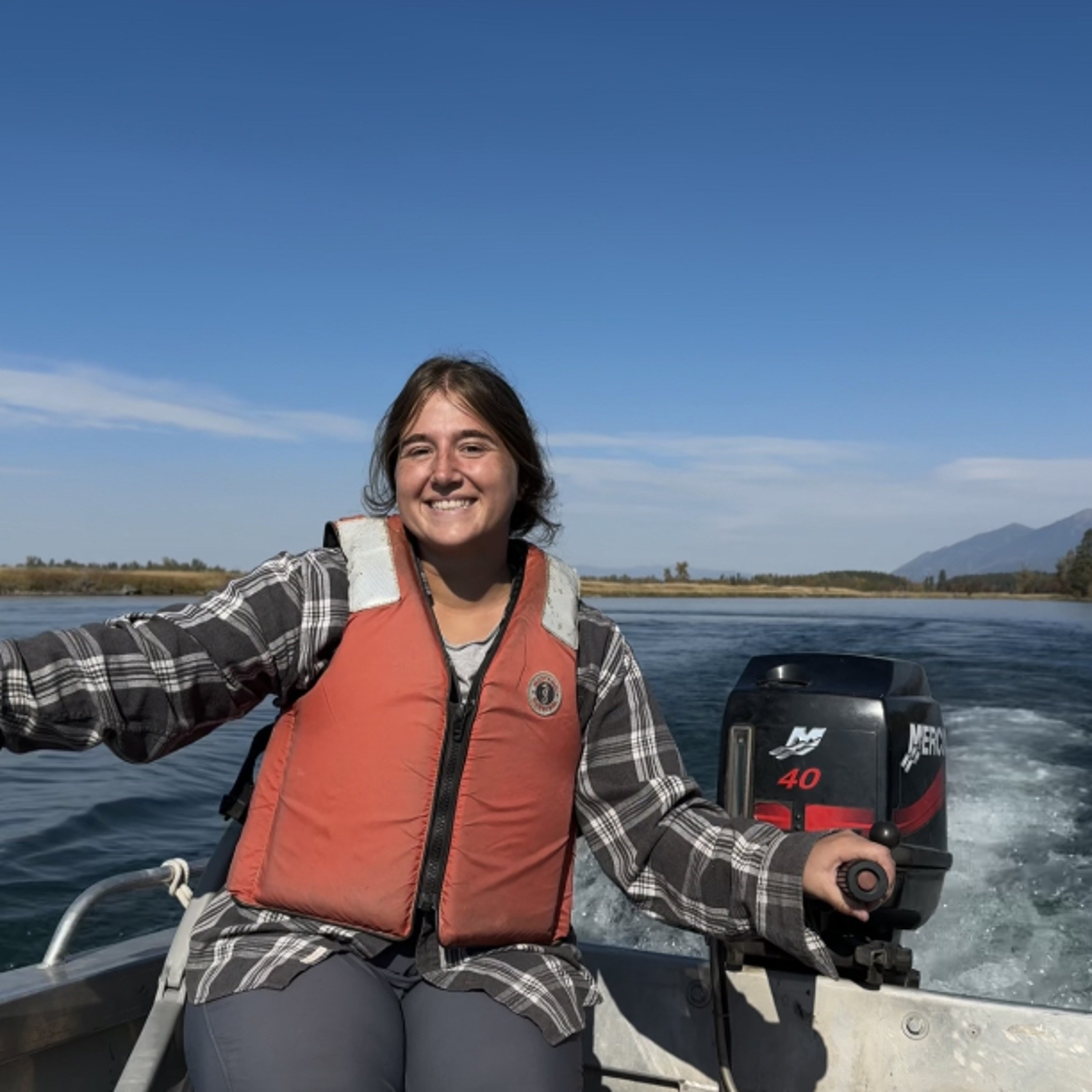 Meredith steers a boat on a lake in the Mission Valley
