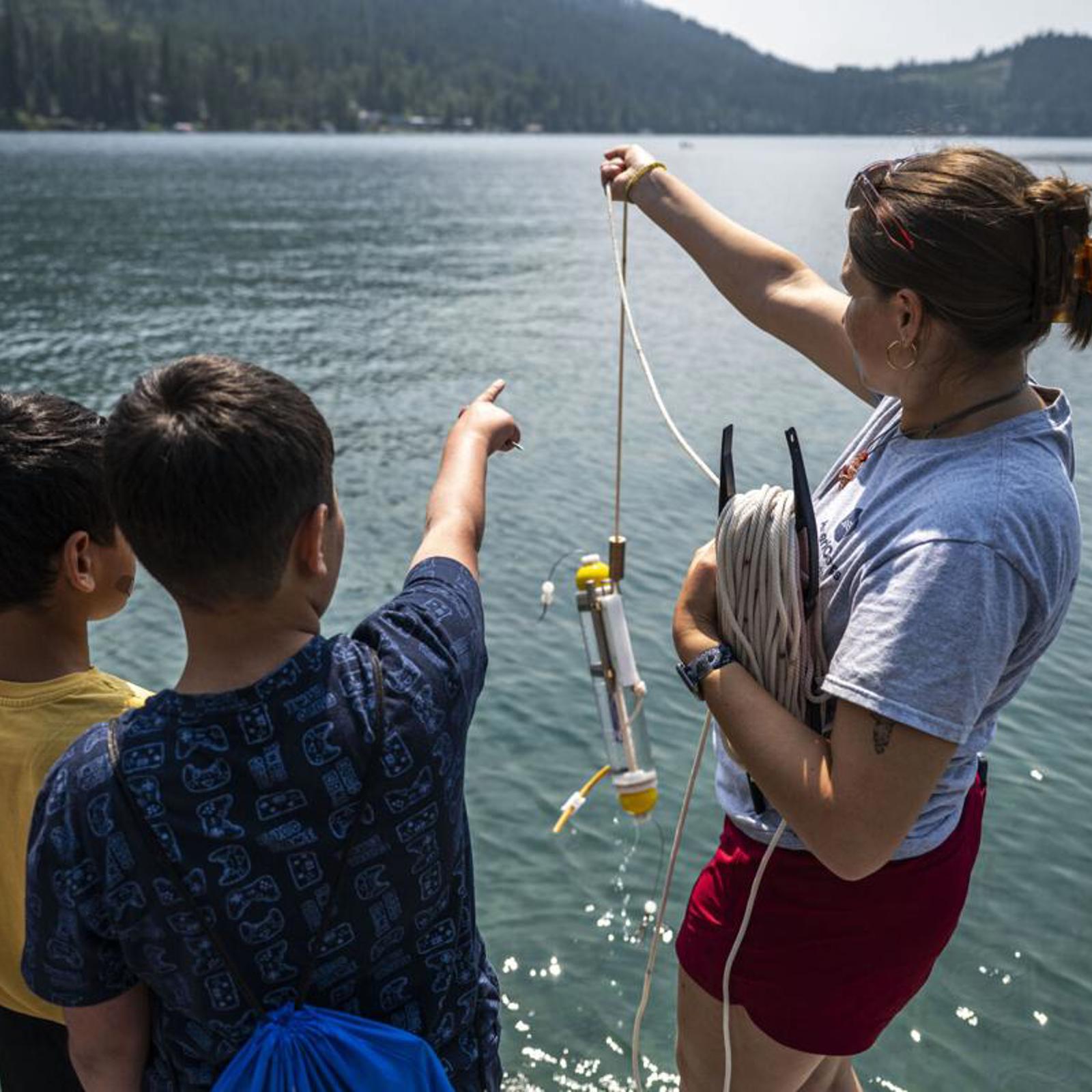 During a field trip hosted by Soft Landing Missoula, Alyssa Schaefer leads children in a water testing science experiment at the Flathead Lake Biological Station on Wednesday, July 22. 