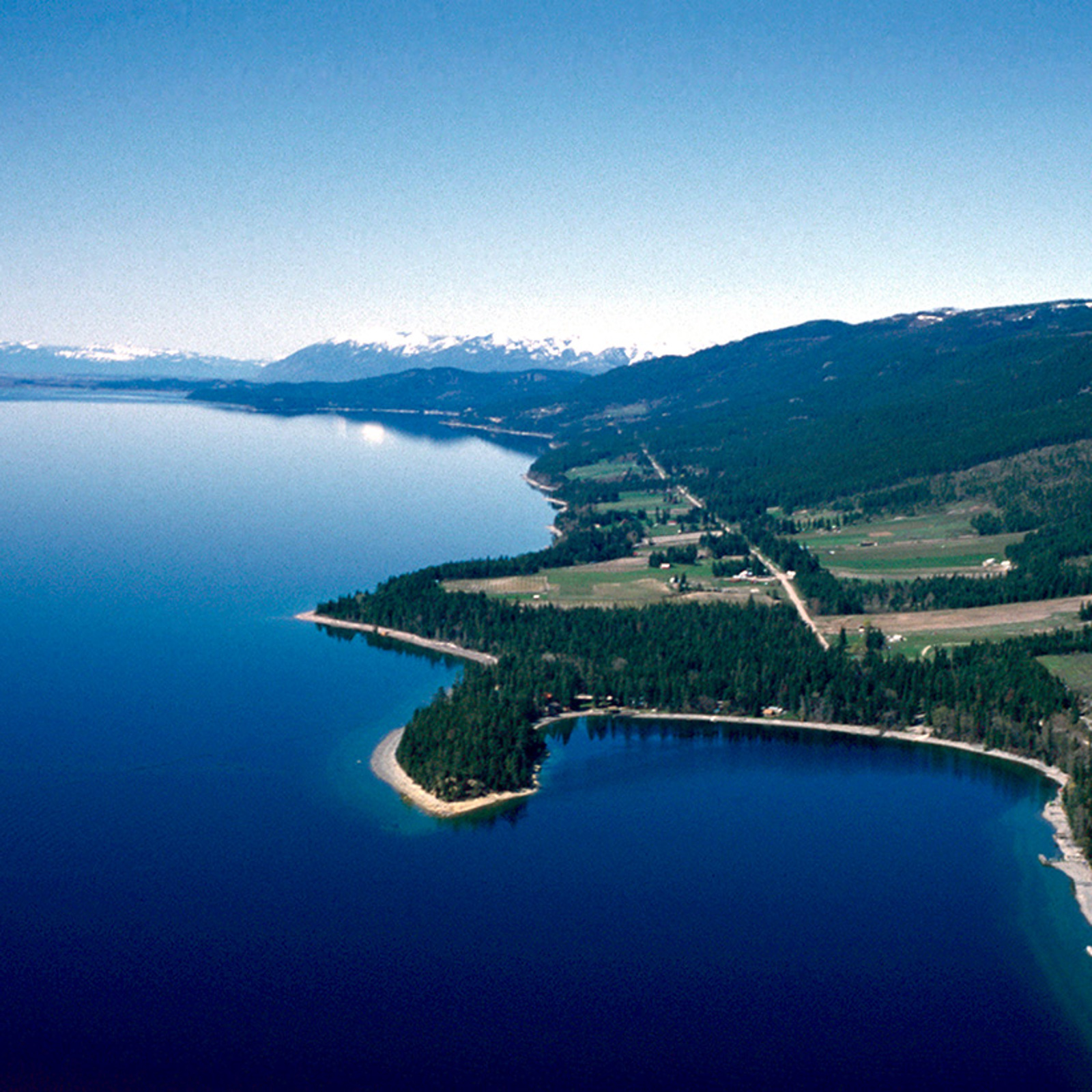 Aerial view of Yellow Bay and the east shoreline of Flathead Lake with the Whitefish Mountains in the background