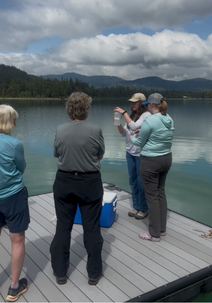 Callie Nelson and Abie Ebert instructing Thompson Chain of Lakes Stewardship Coalition volunteers on how to collect a water sample.