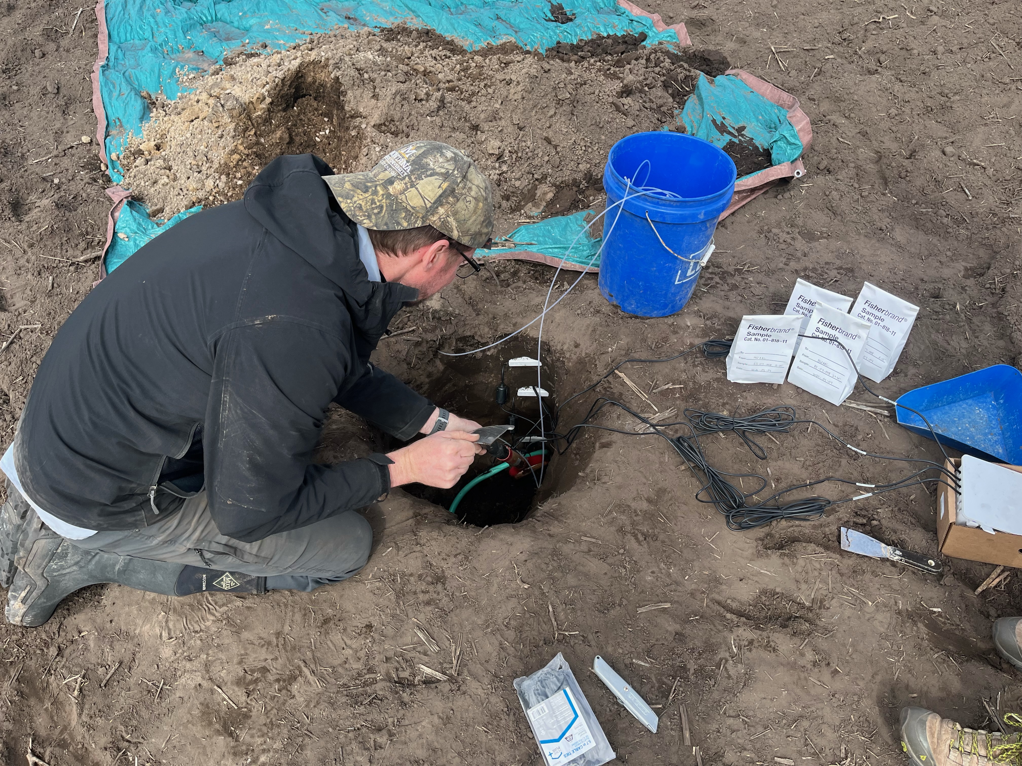 Adam Sigler installs an underground  soil sensor