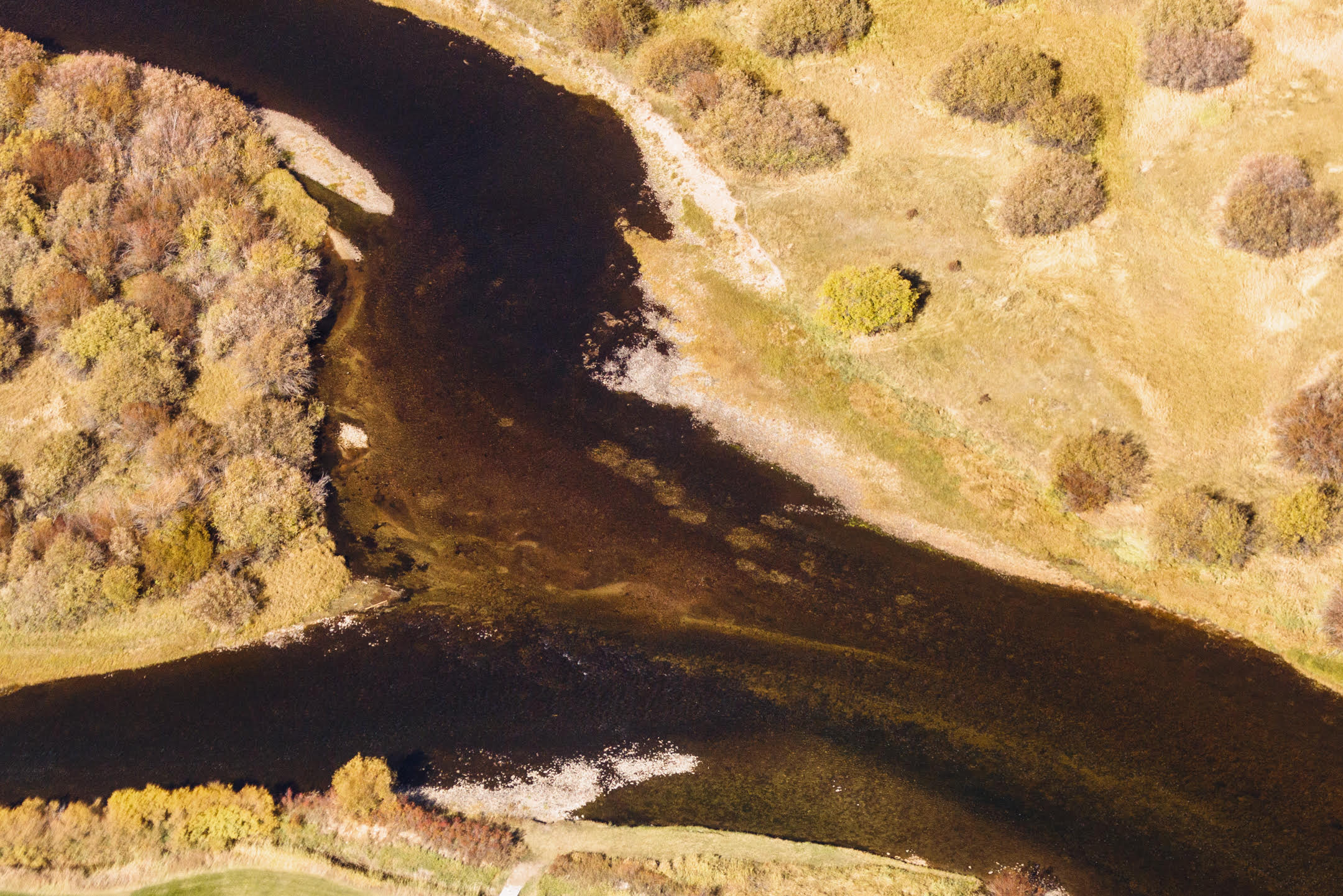 A confluence where one river is separating into two rivers.