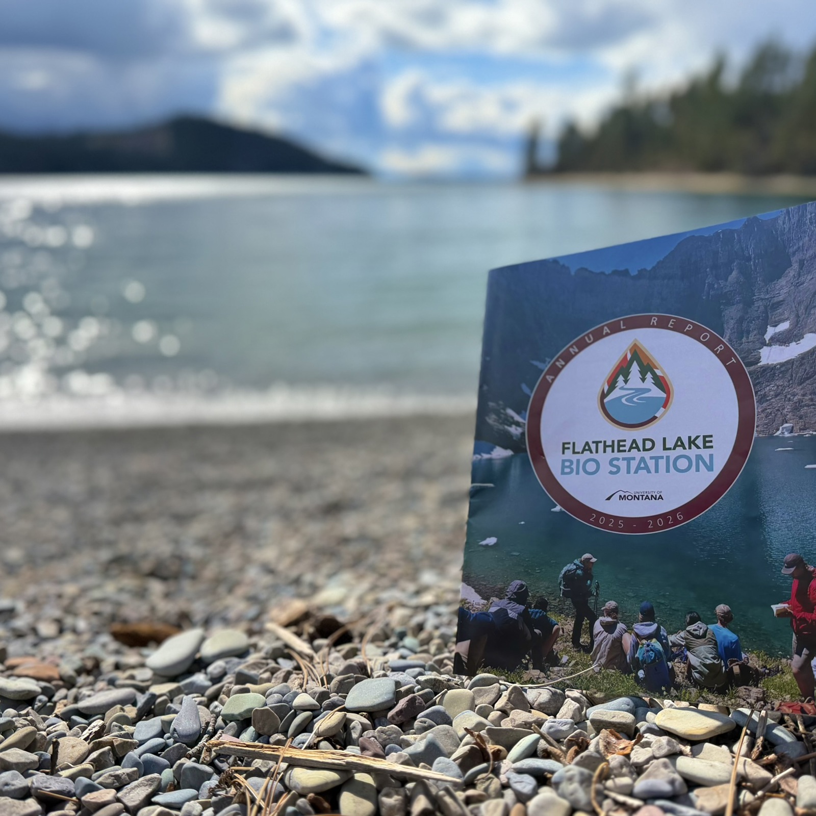 FLBS Annual Report magazine pictured on shore of sunny lake