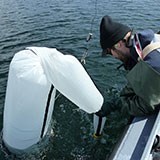 Researcher sampling with the van dorn on Whitefish Lake